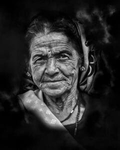 Black and white portrait capturing the wisdom and grace of an elderly Indian woman with expressive wrinkles and traditional attire.